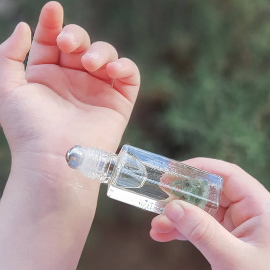 Applying roll on perfume to wrist